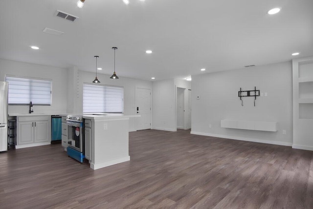 kitchen featuring a kitchen island, appliances with stainless steel finishes, open floor plan, light countertops, and pendant lighting