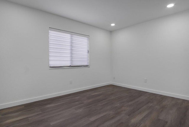 unfurnished room with baseboards, dark wood-style flooring, and recessed lighting