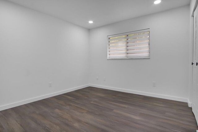 spare room with recessed lighting, dark wood-style flooring, and baseboards