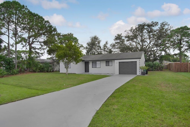 single story home featuring driveway, a garage, fence, and a front yard