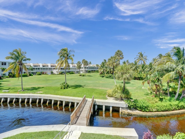 view of dock with a water view and a lawn