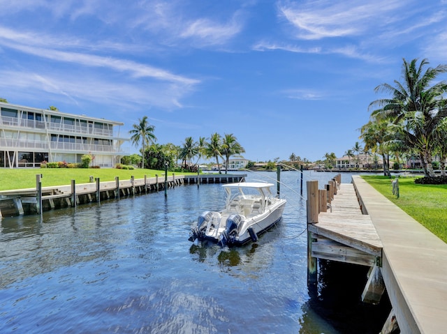 view of dock with a water view and a lawn