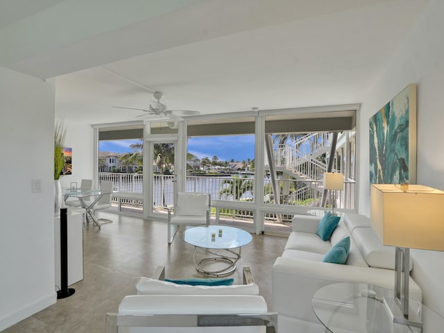 living room with a water view and ceiling fan