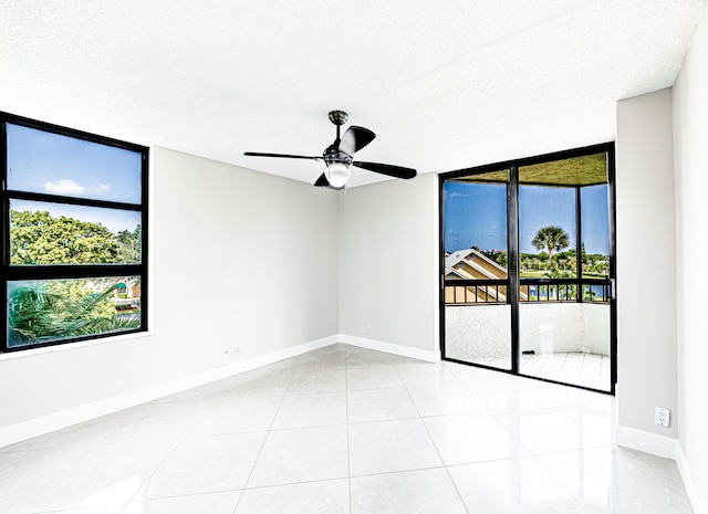 unfurnished room featuring light tile patterned flooring, a textured ceiling, a healthy amount of sunlight, and ceiling fan