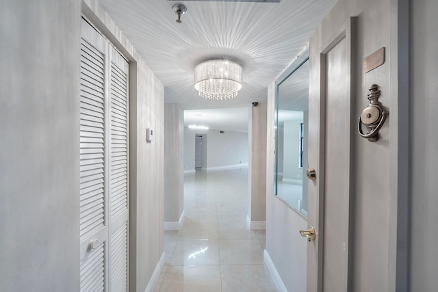 hall featuring a chandelier and light tile patterned flooring