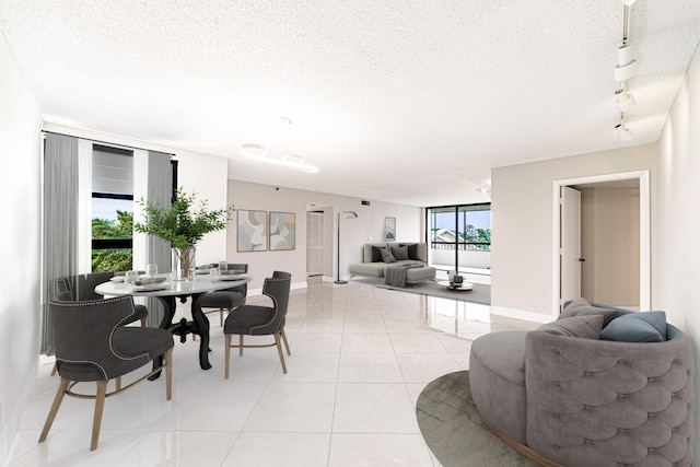 living room with a textured ceiling, rail lighting, and light tile patterned floors