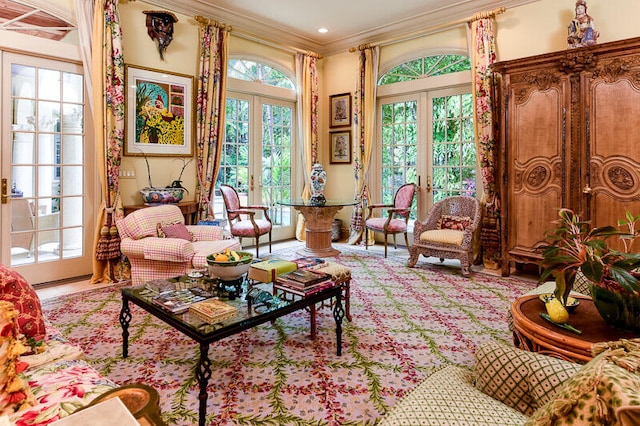 living area with a healthy amount of sunlight, french doors, and crown molding