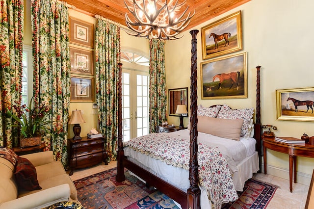 tiled bedroom with a notable chandelier and french doors