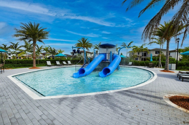 view of pool with a playground, a patio area, and a water slide