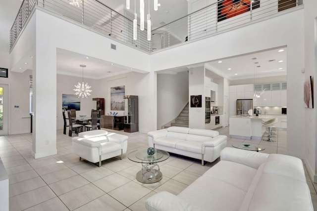 tiled living room with crown molding, a high ceiling, and a notable chandelier