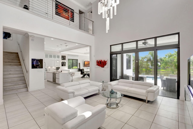 tiled living room featuring a chandelier, a towering ceiling, and a wealth of natural light