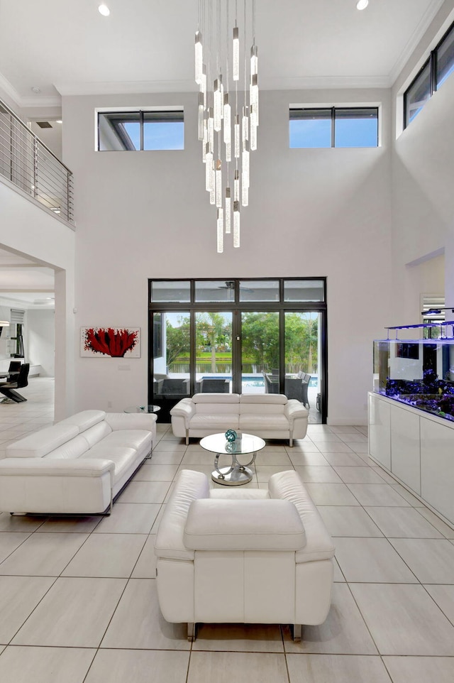 tiled living room with plenty of natural light, a high ceiling, and ornamental molding