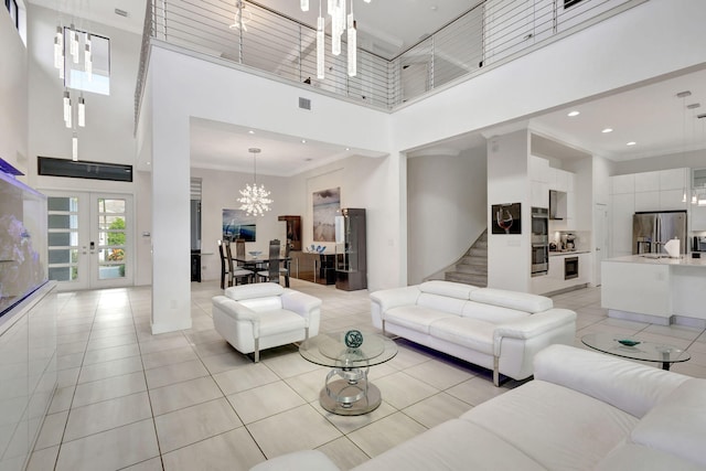 tiled living room featuring a high ceiling, an inviting chandelier, french doors, and ornamental molding