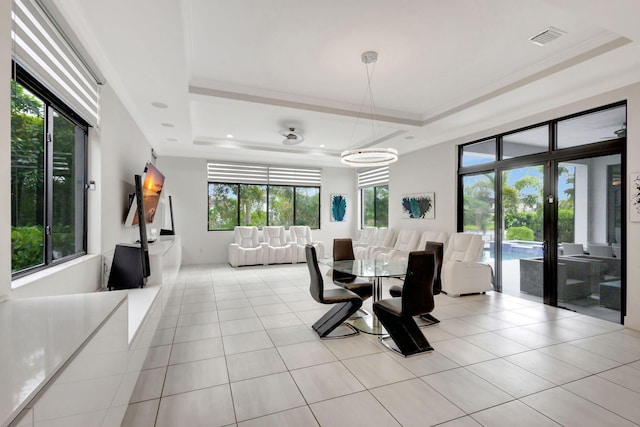 tiled dining room with french doors, a tray ceiling, an inviting chandelier, and ornamental molding