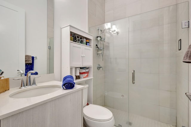 bathroom featuring toilet, an enclosed shower, and vanity