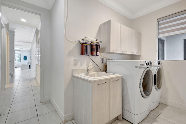 washroom featuring cabinets, light tile patterned floors, washer and clothes dryer, and ornamental molding