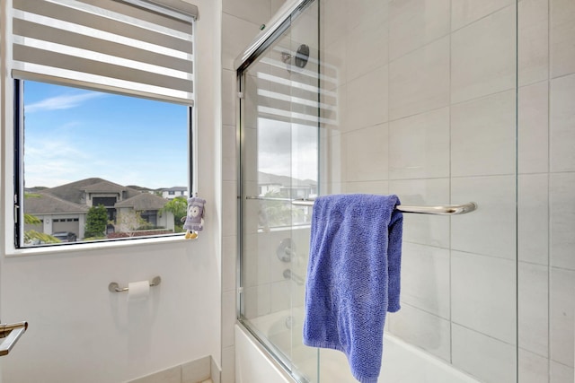 bathroom featuring shower / bath combination with glass door