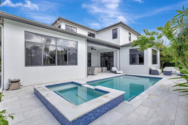 rear view of property with a patio area, ceiling fan, and a swimming pool with hot tub