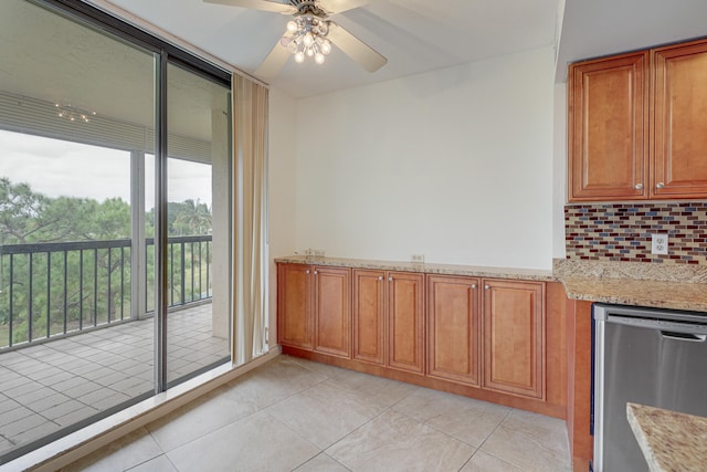 kitchen with tasteful backsplash, ceiling fan, stainless steel dishwasher, light stone counters, and light tile patterned floors