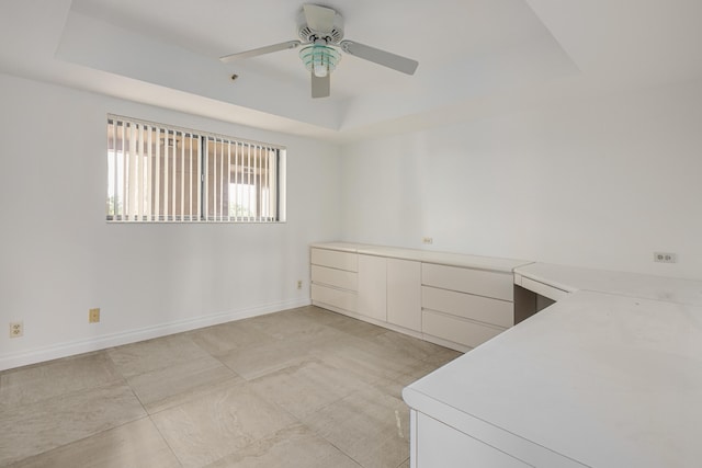 interior space with ceiling fan and a tray ceiling