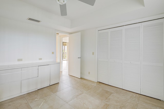 unfurnished bedroom with a closet, light tile patterned flooring, and ceiling fan