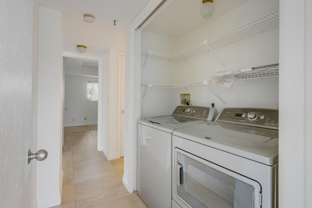 laundry room featuring washing machine and dryer and light tile patterned floors