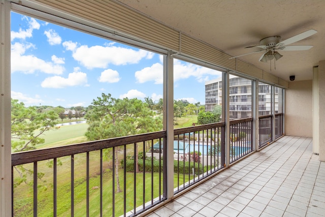 balcony featuring a water view and ceiling fan