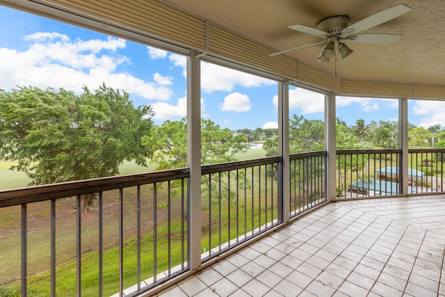 unfurnished sunroom with a water view, ceiling fan, and plenty of natural light