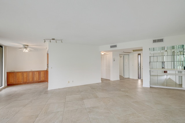 tiled empty room featuring ceiling fan