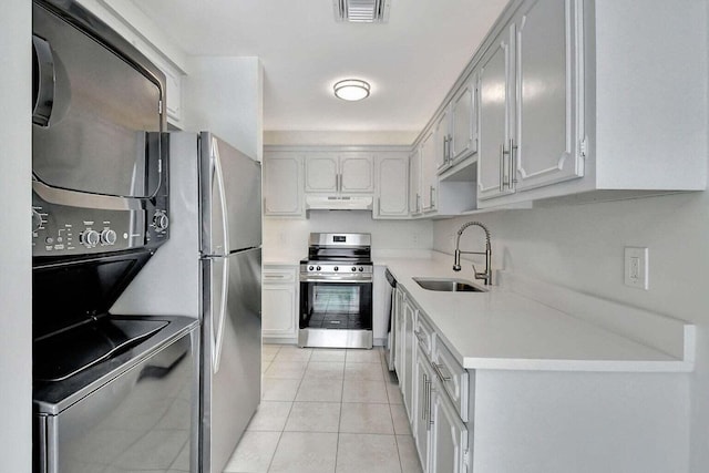 kitchen featuring white cabinetry, light tile patterned floors, gas stove, and sink