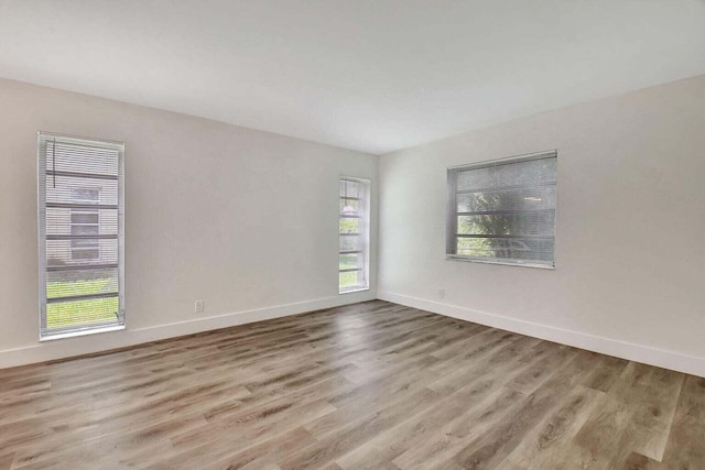 spare room featuring light hardwood / wood-style floors and plenty of natural light