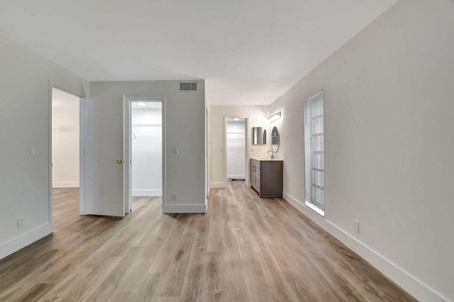 unfurnished living room featuring sink and light wood-type flooring