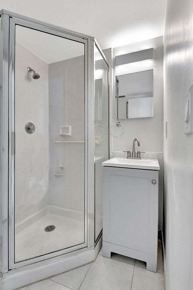 bathroom featuring vanity, walk in shower, and tile patterned flooring