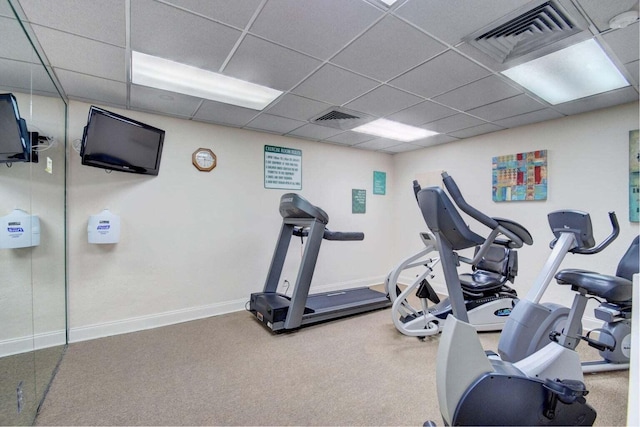 exercise room featuring a paneled ceiling and carpet