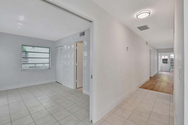 hall with light tile patterned floors and a wealth of natural light