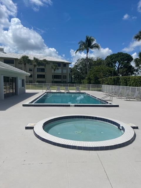 view of swimming pool featuring a hot tub and a patio