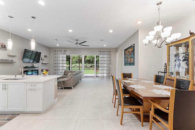 dining area featuring sink, ceiling fan with notable chandelier, and light tile patterned floors