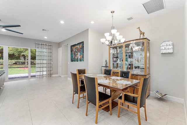 tiled dining room with ceiling fan with notable chandelier