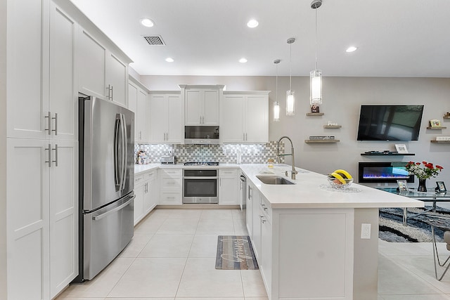 kitchen featuring sink, light tile patterned flooring, decorative light fixtures, white cabinetry, and appliances with stainless steel finishes