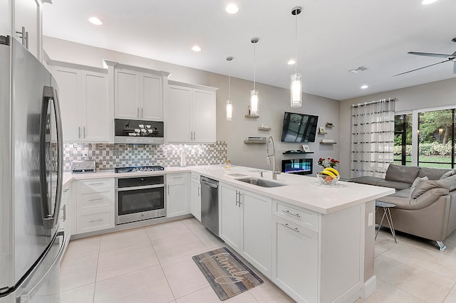 kitchen with white cabinetry, stainless steel appliances, sink, and pendant lighting