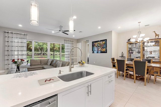 kitchen with sink, white cabinetry, decorative light fixtures, and ceiling fan with notable chandelier