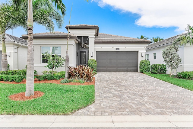 view of front of home with a front yard and a garage