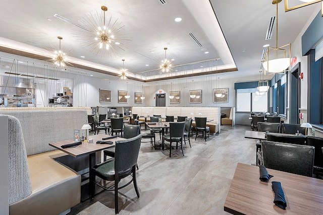 dining room with a raised ceiling and a chandelier