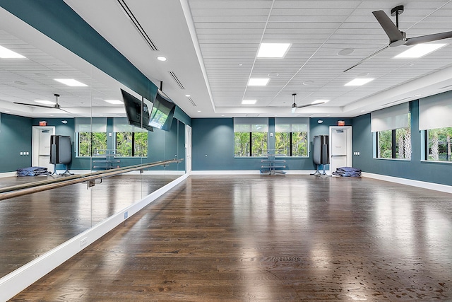 workout room with dark hardwood / wood-style floors, a paneled ceiling, and ceiling fan