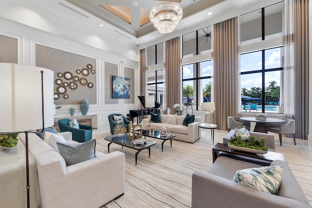 living room featuring ornamental molding, a high ceiling, and a notable chandelier