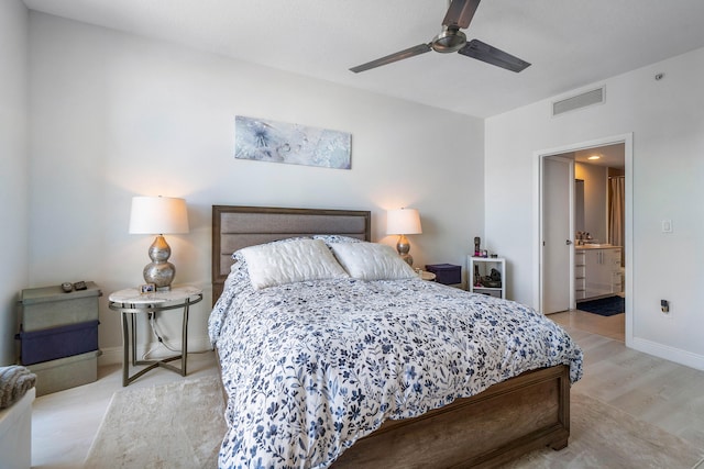 bedroom featuring light hardwood / wood-style flooring, ceiling fan, and ensuite bath