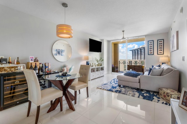 tiled dining space with wine cooler, a textured ceiling, a wall of windows, and ceiling fan