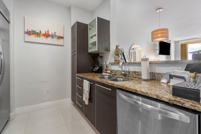 kitchen featuring dishwasher, dark stone counters, sink, dark brown cabinetry, and light tile patterned floors