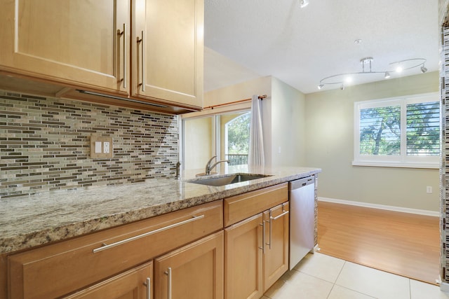 kitchen with kitchen peninsula, stainless steel appliances, sink, light hardwood / wood-style flooring, and hanging light fixtures