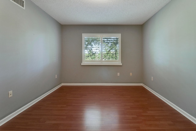 unfurnished bedroom featuring hardwood / wood-style flooring, a textured ceiling, and a closet